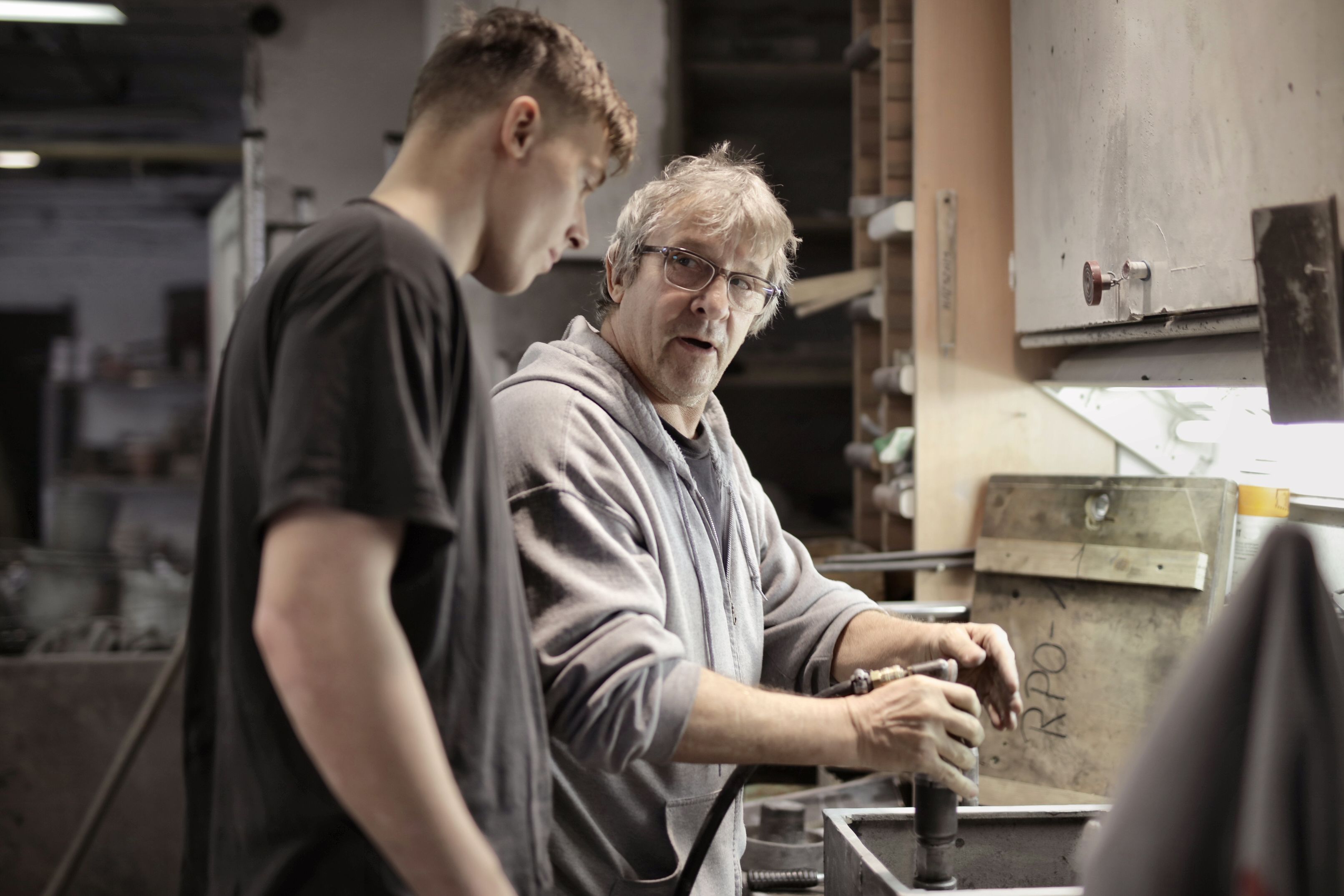 Experienced technician mentoring an apprentice in an industrial setting